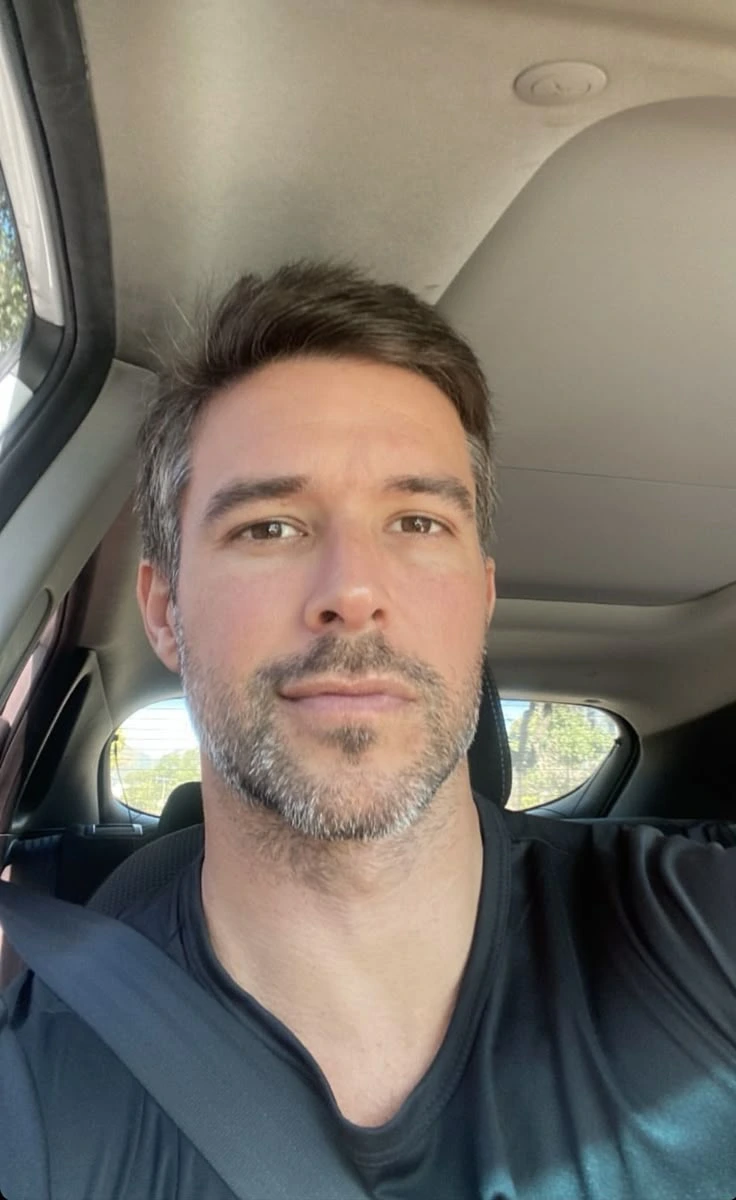 Close-up portrait of a relaxed adult man inside a car, representing real consumer satisfaction and lifestyle freedom.
