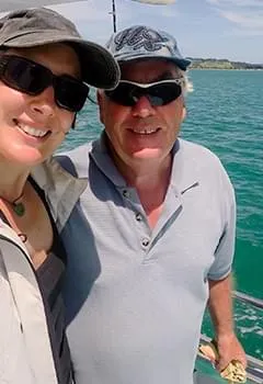 Smiling mature couple posing for a selfie on a boat trip, representing energy, active lifestyle, and vitality.