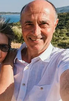 Close-up outdoor portrait of a middle-aged couple smiling together, illustrating relationship satisfaction and wellness.